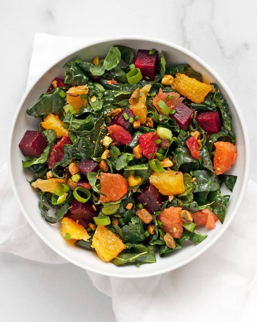 Kale salad in a bowl with roasted beets and oranges