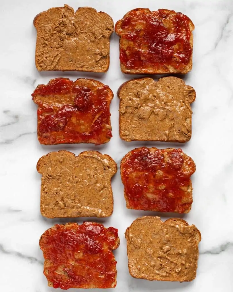 Spreading almond butter and jelly on slices of bread
