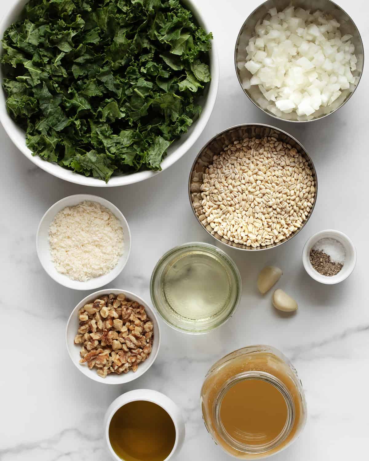Ingredients including kale, pearl barley, onions, olive oil, Parmesan, garlic, walnuts, white wine, salt and pepper.