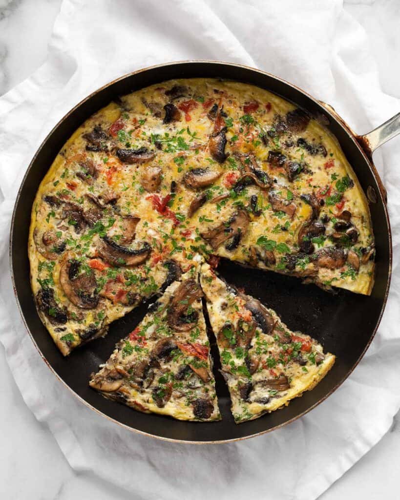 Sliced mushroom tomato frittata in a skillet