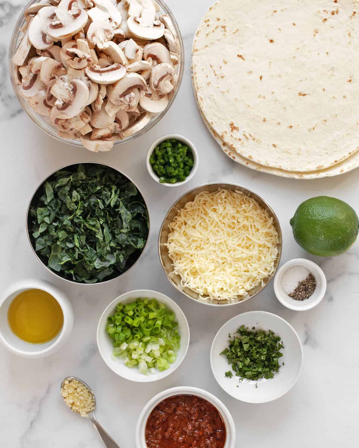 Ingredients including mushrooms, kale, tortillas, jalapeños, garlic, cheese, salt, pepper and oil.