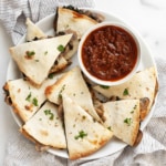 Sheet pan mushroom quesadillas on a plate with salsa.