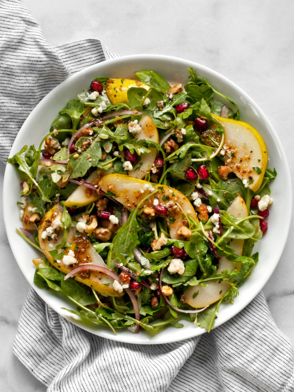 Arugula salad with pears and gorgonzola on a plate.