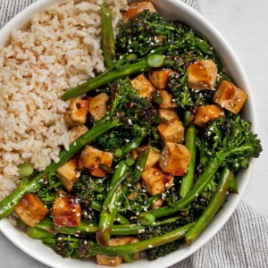 Teriyaki tofu with broccolini and brown rice in a bowl.