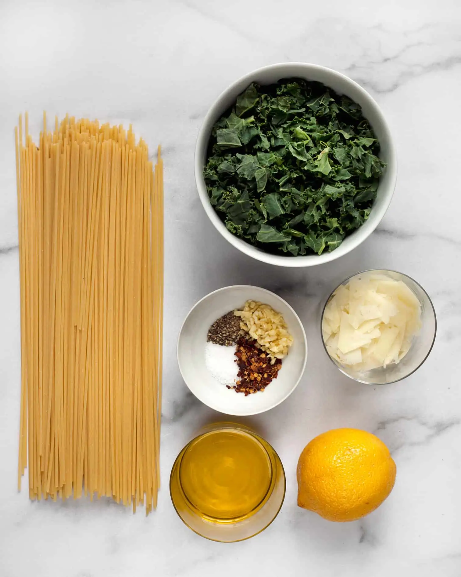 Ingredients including spaghetti, kale, lemon, garlic, olive oil and spices