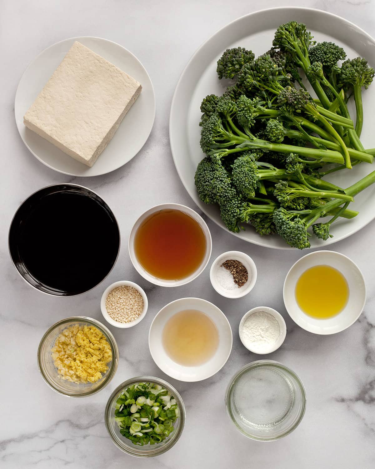 Ingredients including tofu, broccolini, soy sauce, garlic, ginger, oil, salt, pepper and maple syrup.