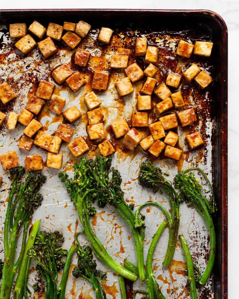 Roasted broccolini and tofu on a sheet pan tossed in teriyaki sauce