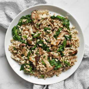 Barley with mushrooms and spinach on a plate.