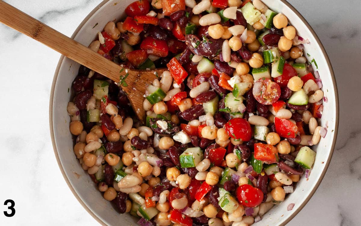 Three bean salad stirred together in a large mixing bowl.