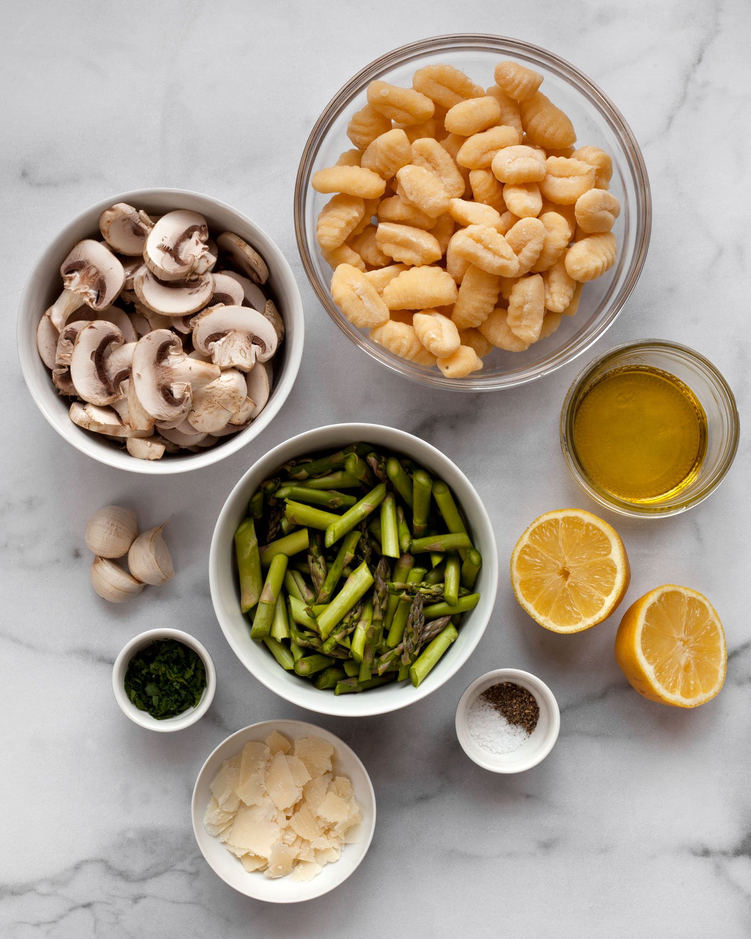Ingredients including gnocchi, mushrooms, asparagus, lemon, garlic, olive oil, Parmesan and parsley.