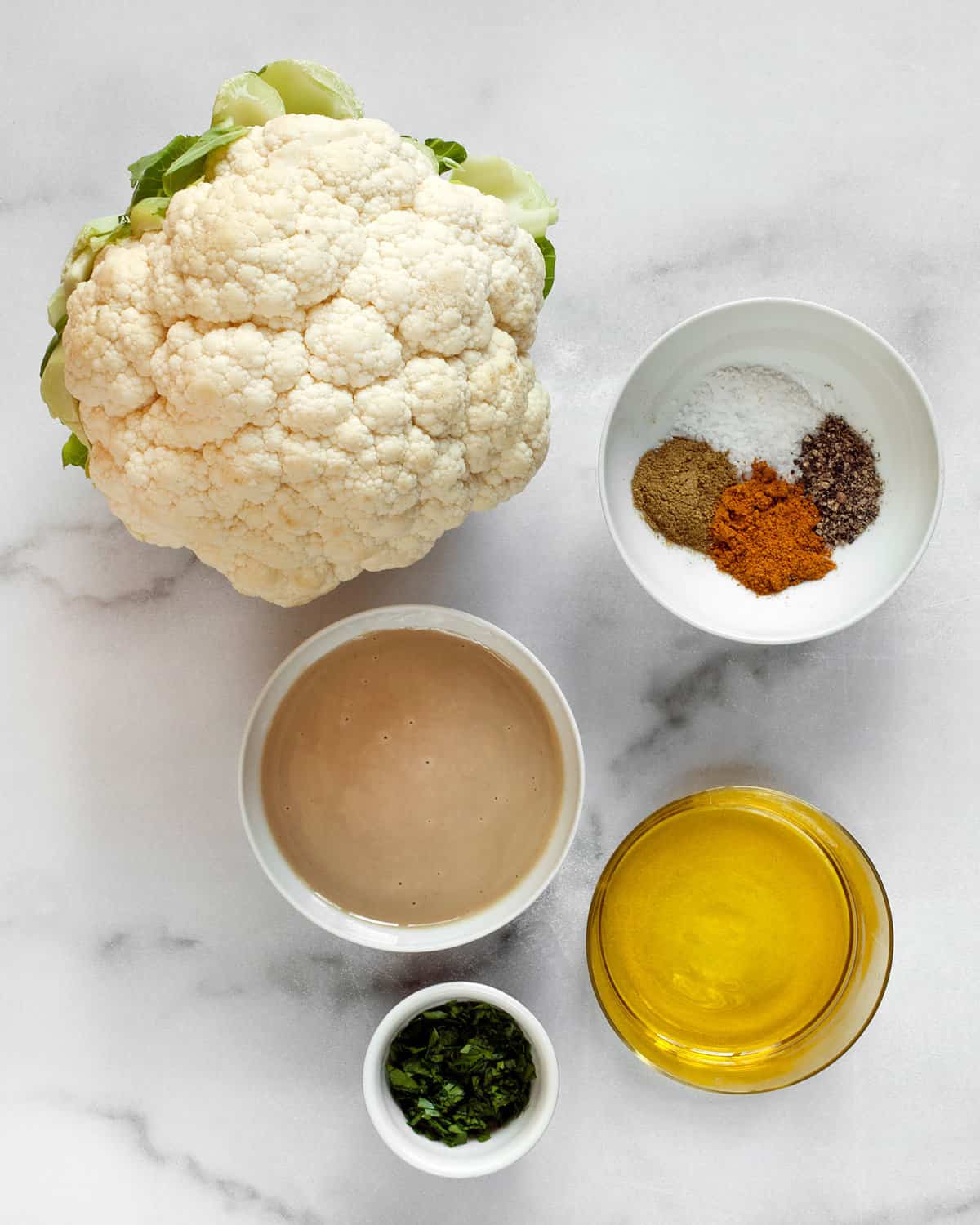 Ingredients including cauliflower, tahini, olive oil and spices