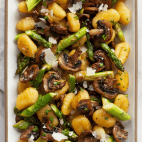 Gnocchi with roasted mushrooms and asparagus on a plate.