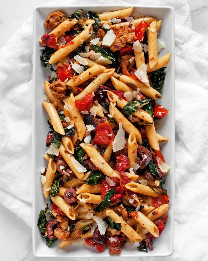 Penne with tomatoes, olives, sausage and kale