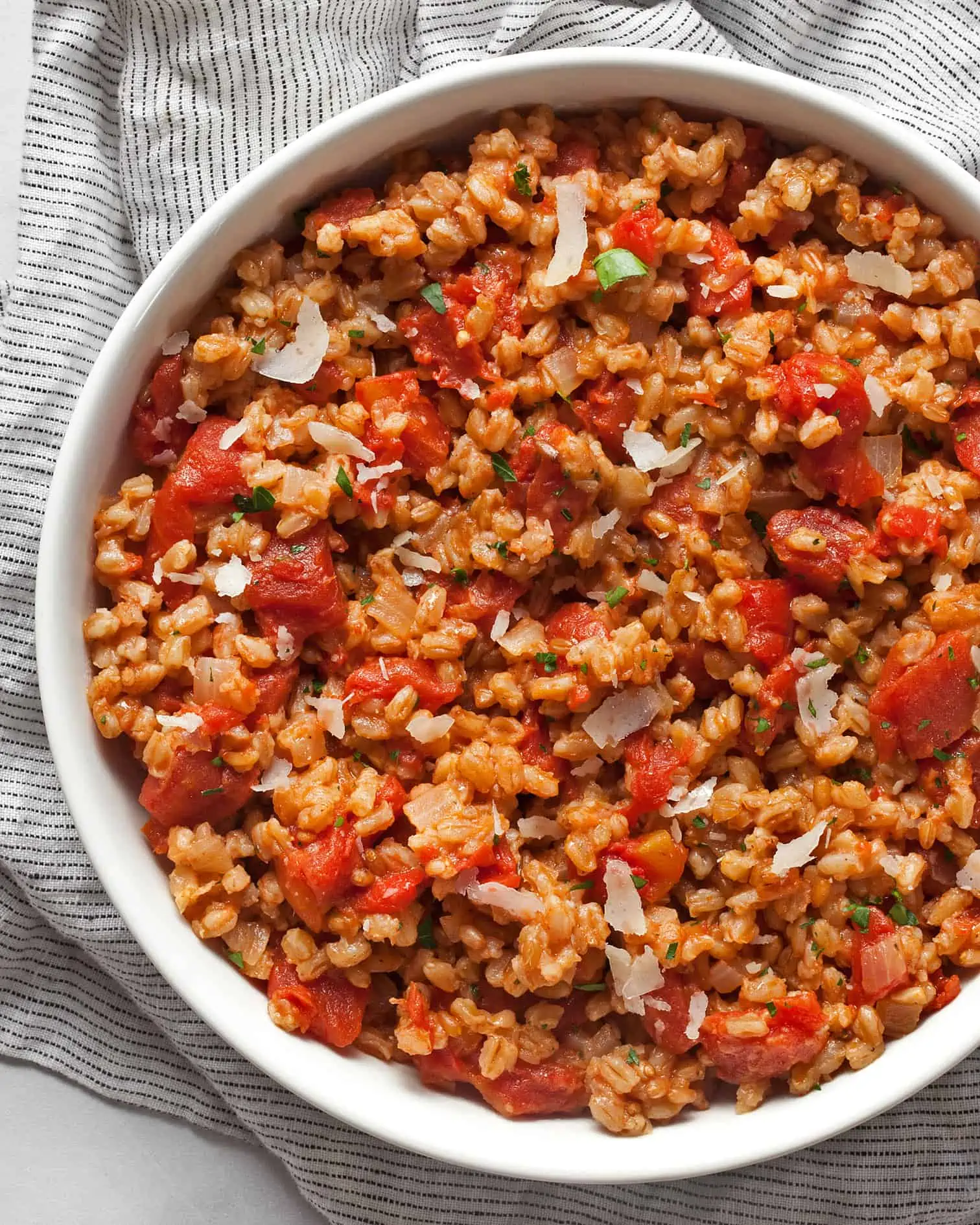Baked farro risotto with tomatoes in a bowl.