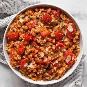 Baked farro risotto with tomatoes in a bowl.