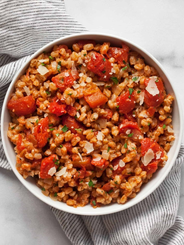 Baked farro risotto with tomatoes in a bowl.