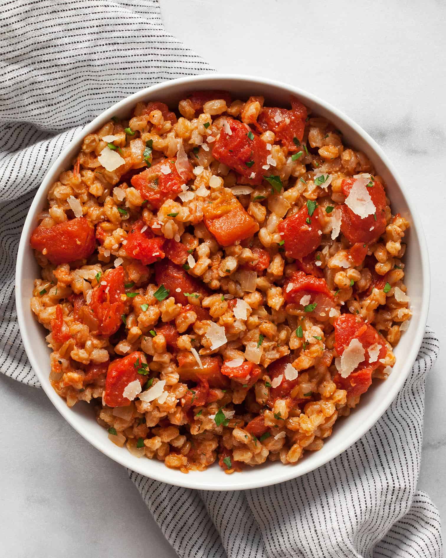 Baked farro risotto with tomatoes in a bowl.