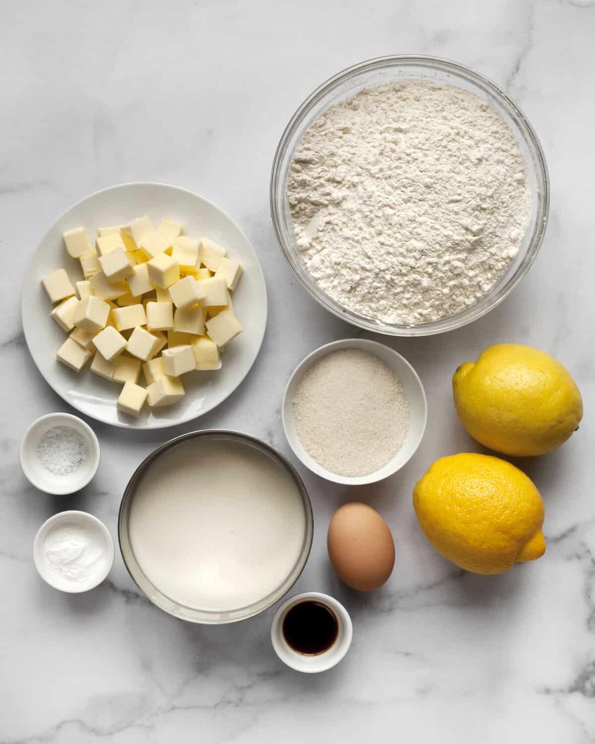 Ingredients including flour, butter, sugar, lemons, baking powder, egg, vanilla extract and salt.