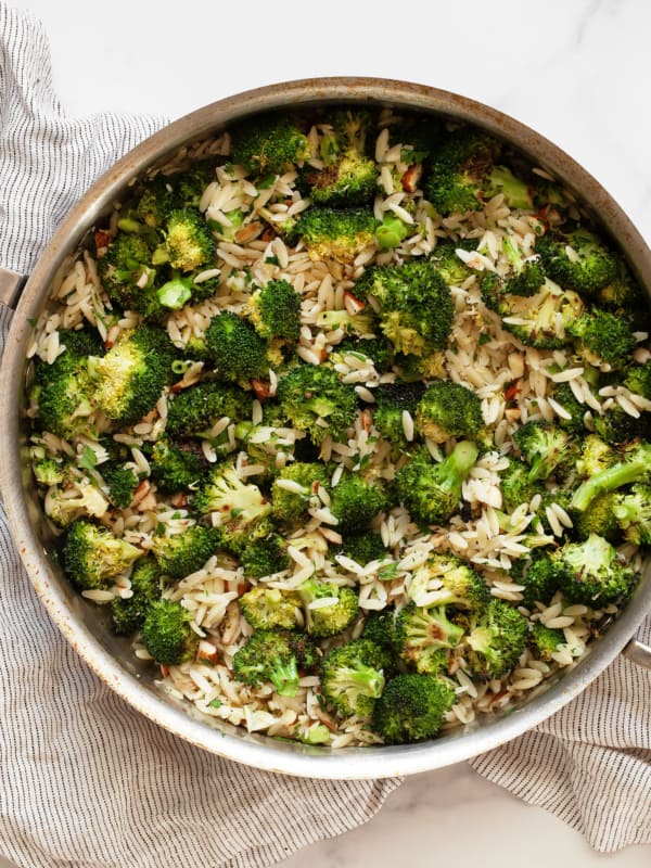 Orzo with roasted broccoli in a sauté pan.