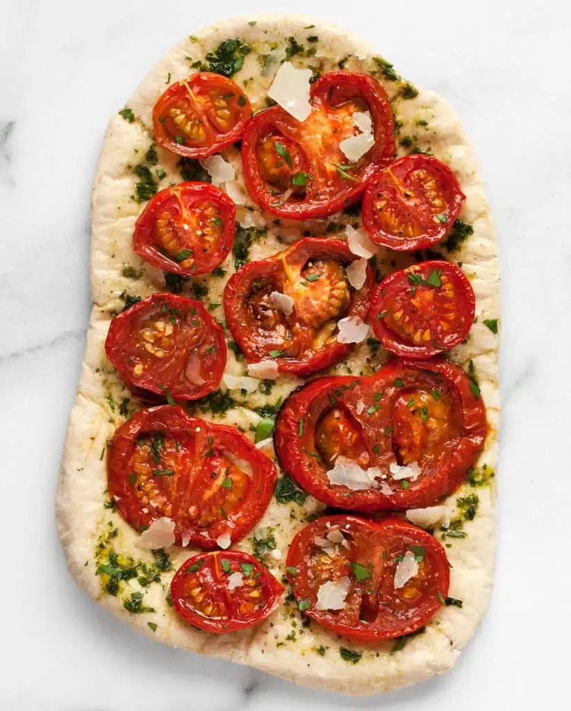Roasted tomatoes topping a pesto pizza