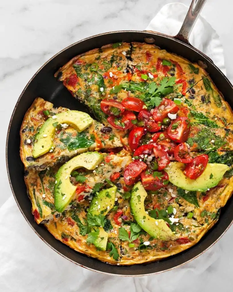 Black Bean Roasted Pepper Frittata topped with cherry tomatoes and avocado