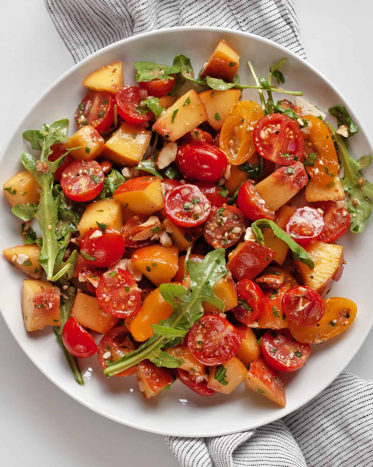 Balsamic peach tomato salad on a plate.