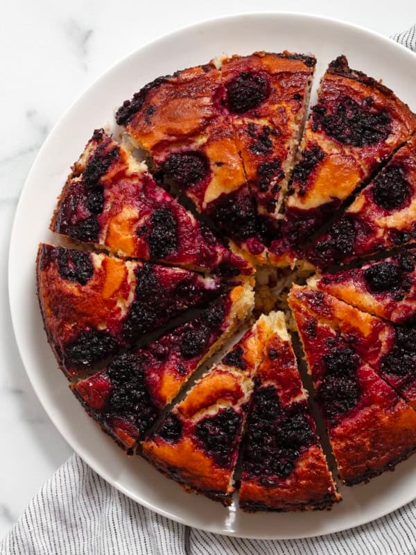 Sliced blackberry lemon cake on a serving plate.
