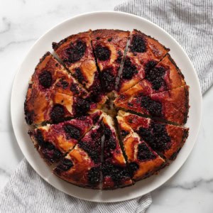 Sliced blackberry lemon cake on a serving plate.