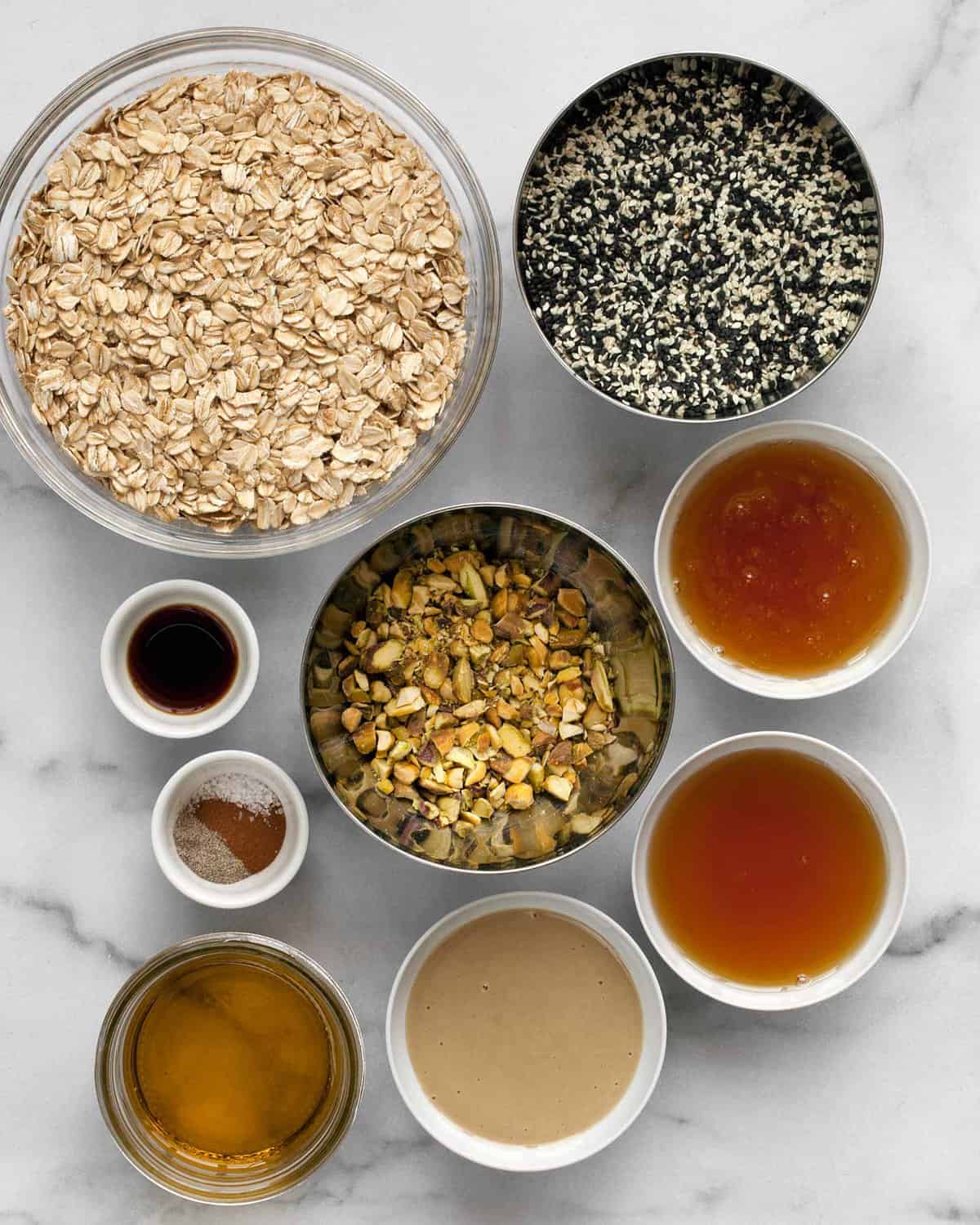 Ingredients including oats, sesame seeds, honey, pistachios, maple syrup, and spices.