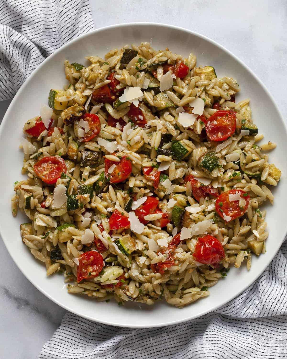 Tomato zucchini orzo on a plate.