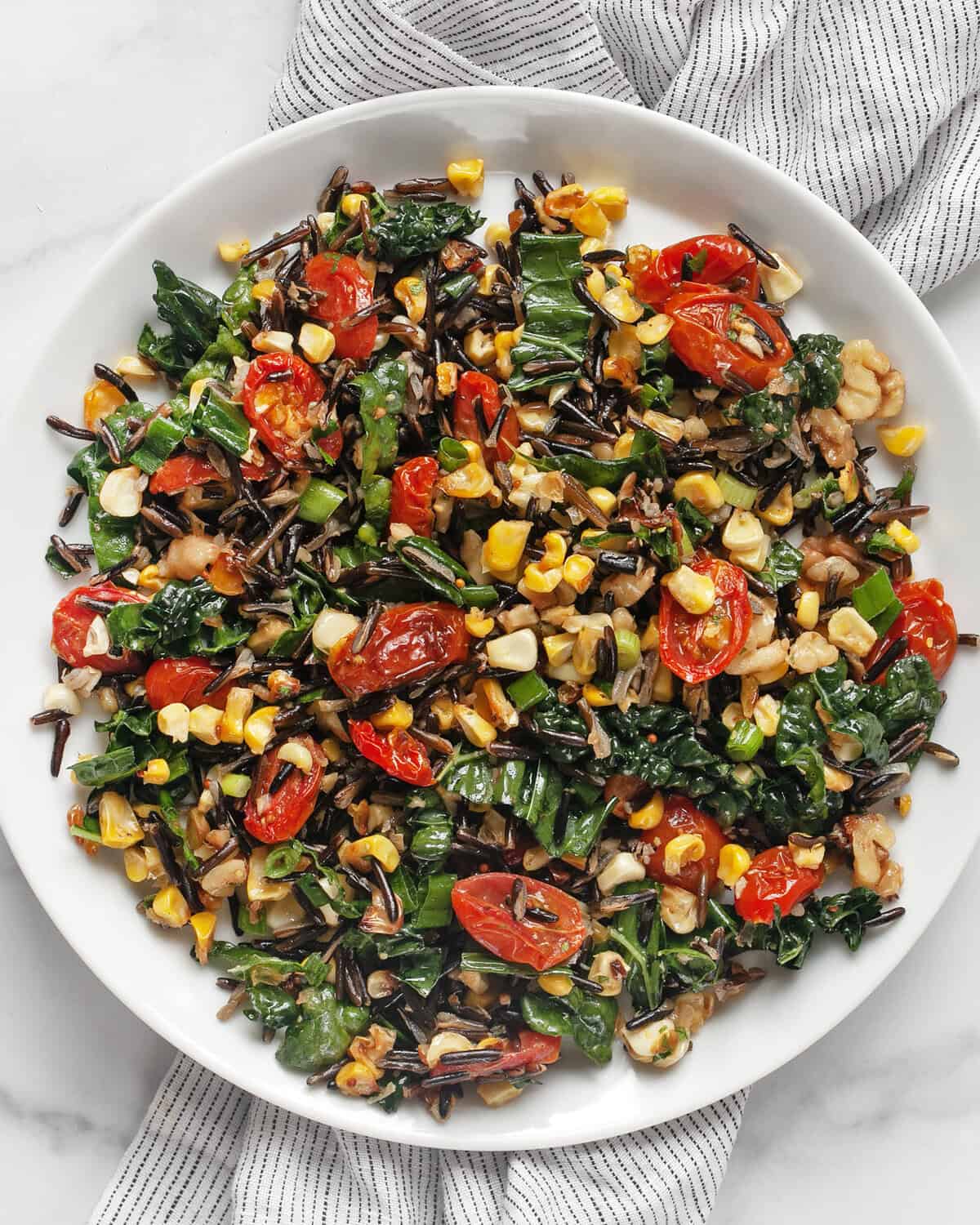 Roasted corn and tomato wild rice salad in on a plate.
