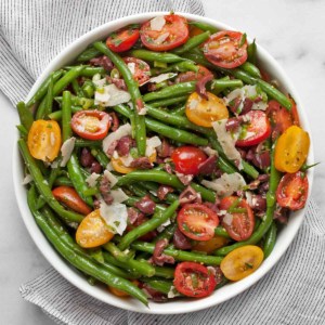 Green bean tomato olive salad in a bowl.