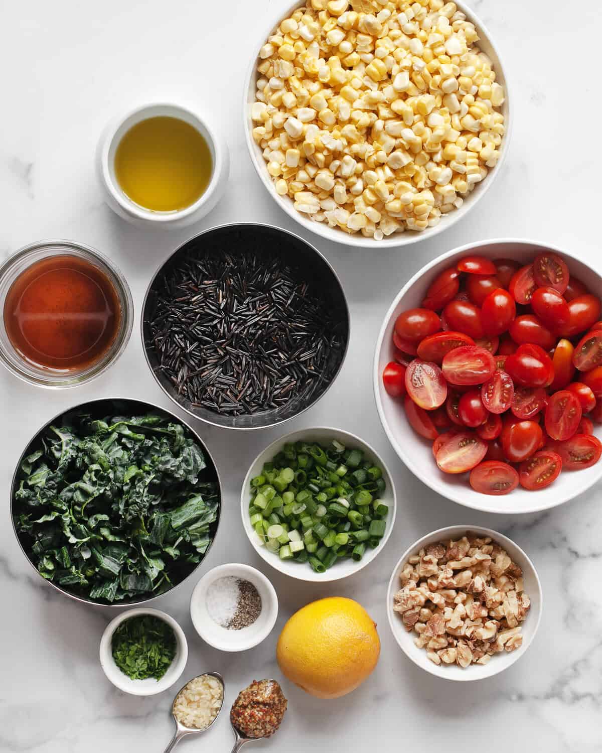 Ingrédients, y compris maïs, tomates, riz sauvage, oignons verts, noix, persil, huile d'olive, ail, citron, vinaigre de vin rouge, sel et poivre.