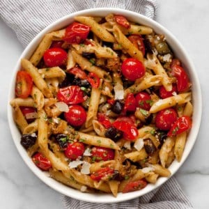 Penne pasta with tomatoes and eggplant in a bowl.