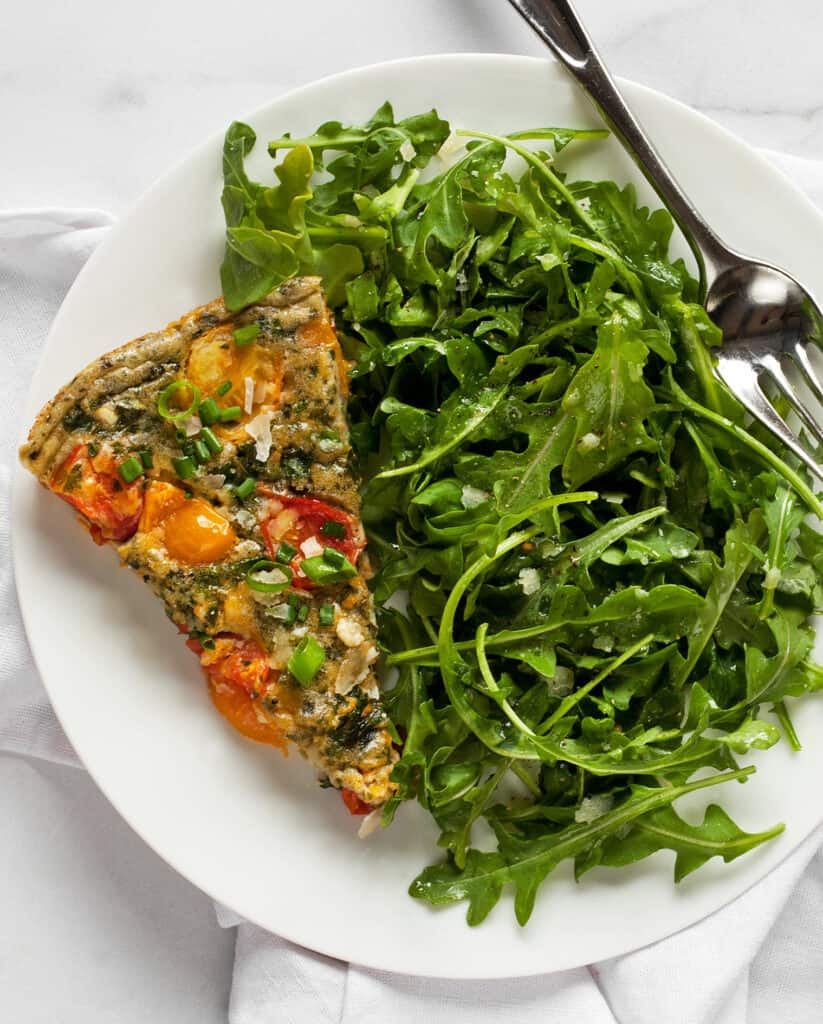 Slice of frittata with mixed greens salad