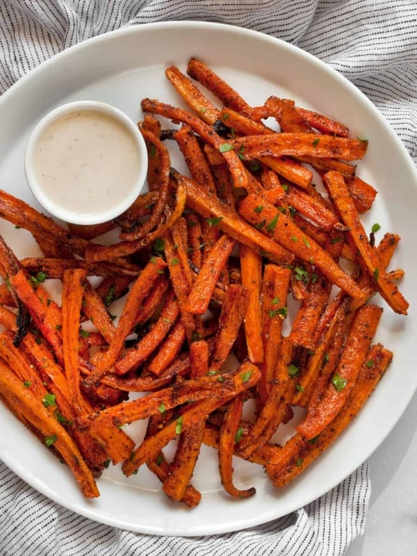 Healthy baked fries on a plate with tahini dipping sauce.