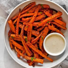 Bowl of carrot french fries with tahini dipping sauce.