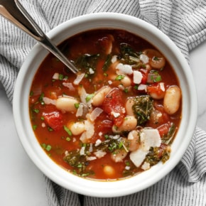 White bean tomato soup with fresh rosemary in a bowl.