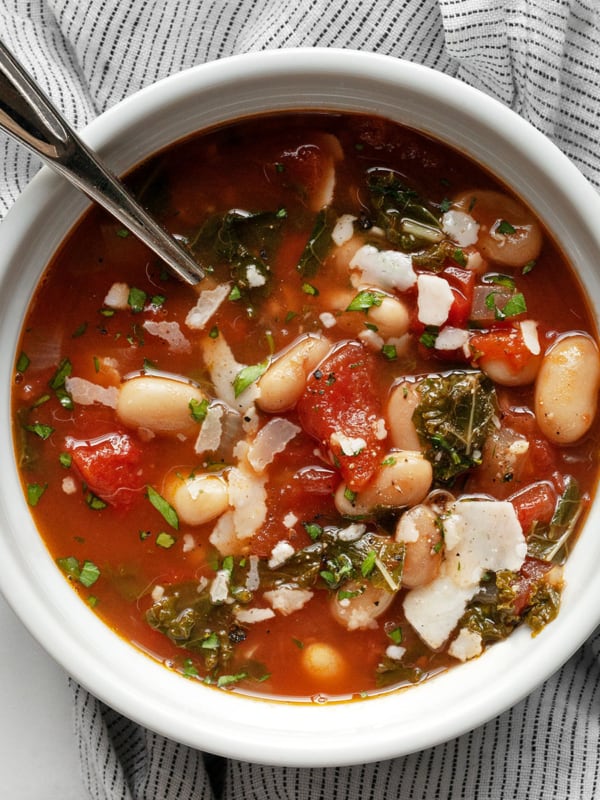 White bean tomato soup with fresh rosemary in a bowl.