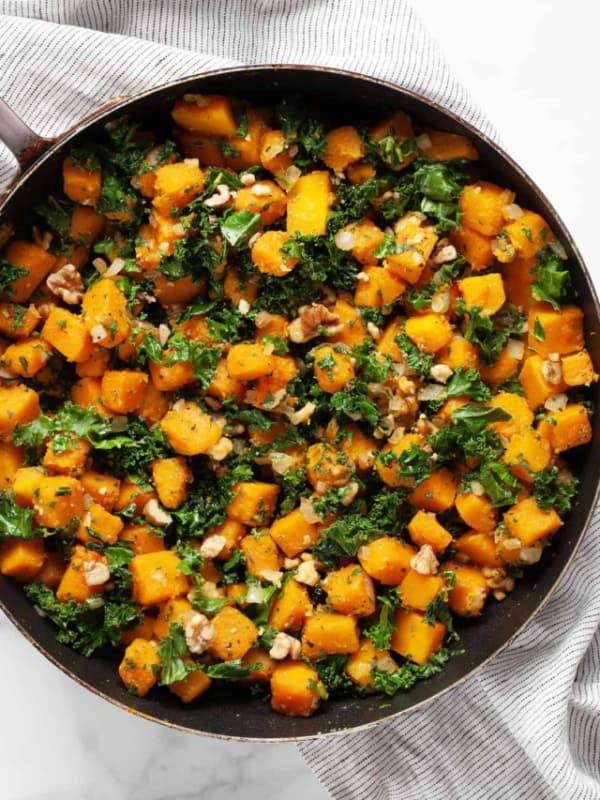 Sautéed butternut squash and kale in a skillet.