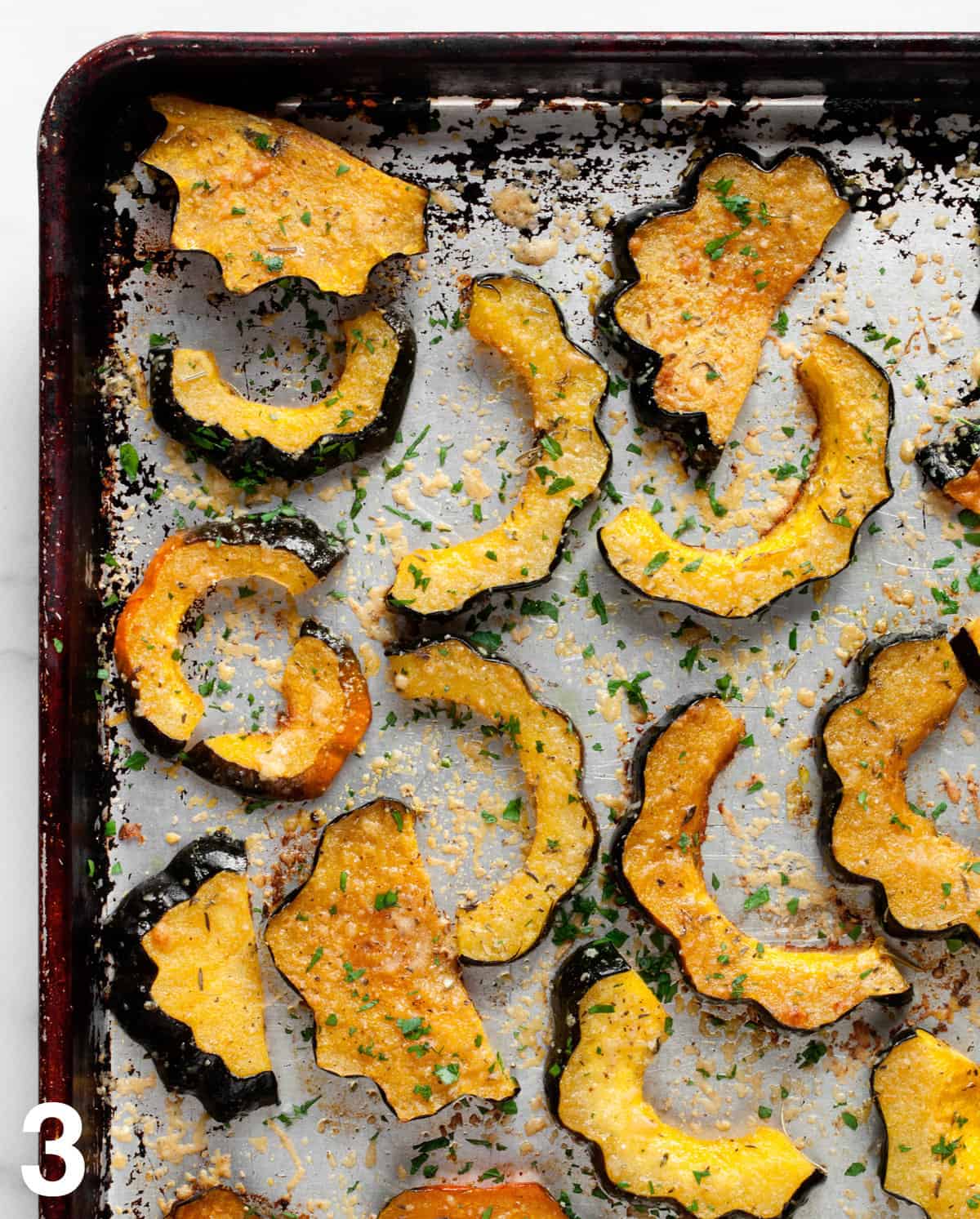 Roated parmesan herb acorn squash on a sheet pan.