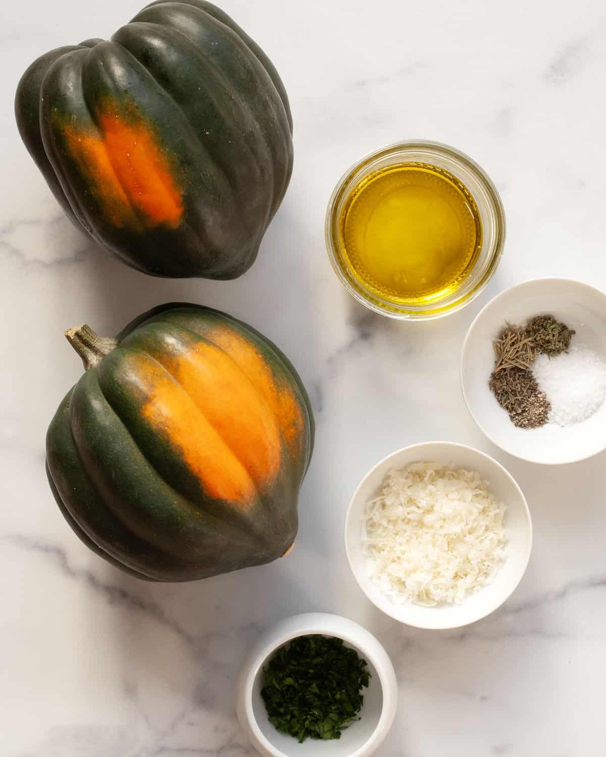 Ingredients including acorn squash, parmesan, spices and parsley.