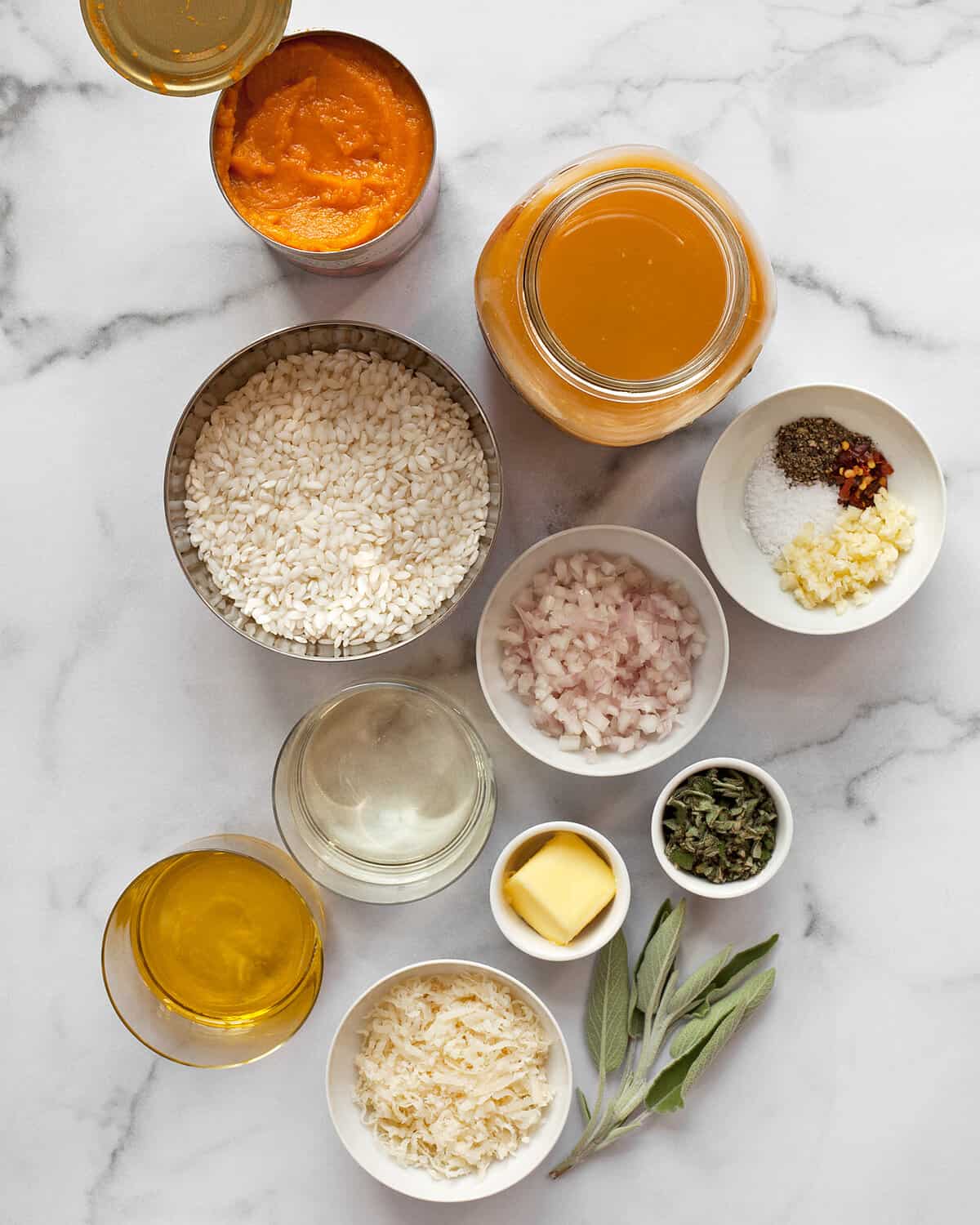 Ingredients including arborio rice, pumpkin puree, parmesan, garlic, shallots, olive oil, vegetable broth, sage and spices.