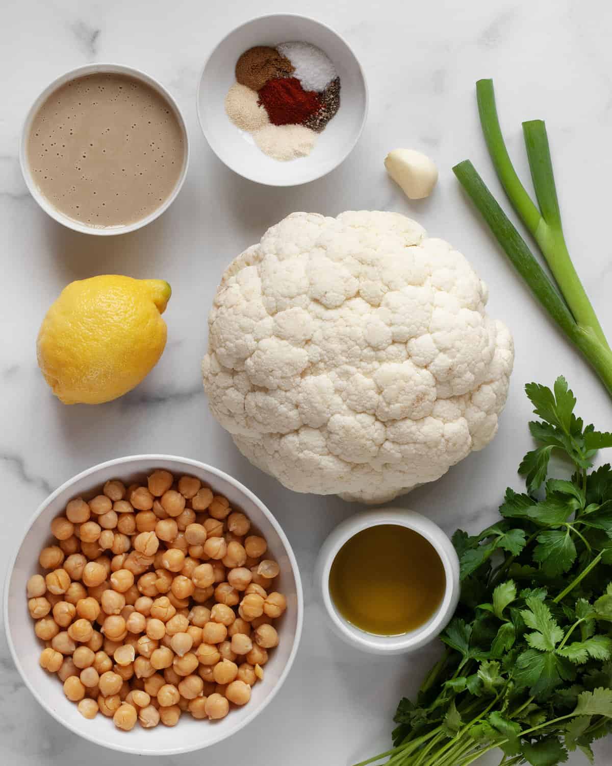 Ingredients including cauliflower, chickpeas, tahini, lemon, garlic, herbs, olive oil and spices.