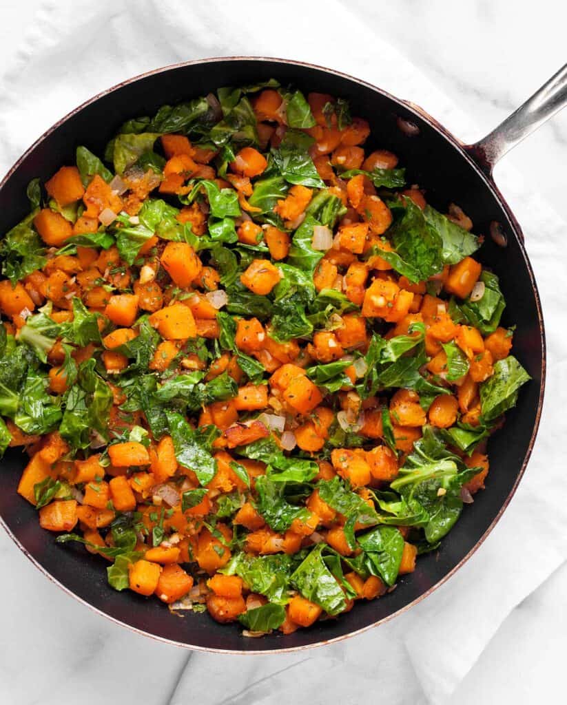 Sauteed kale and butternut squash in a skillet