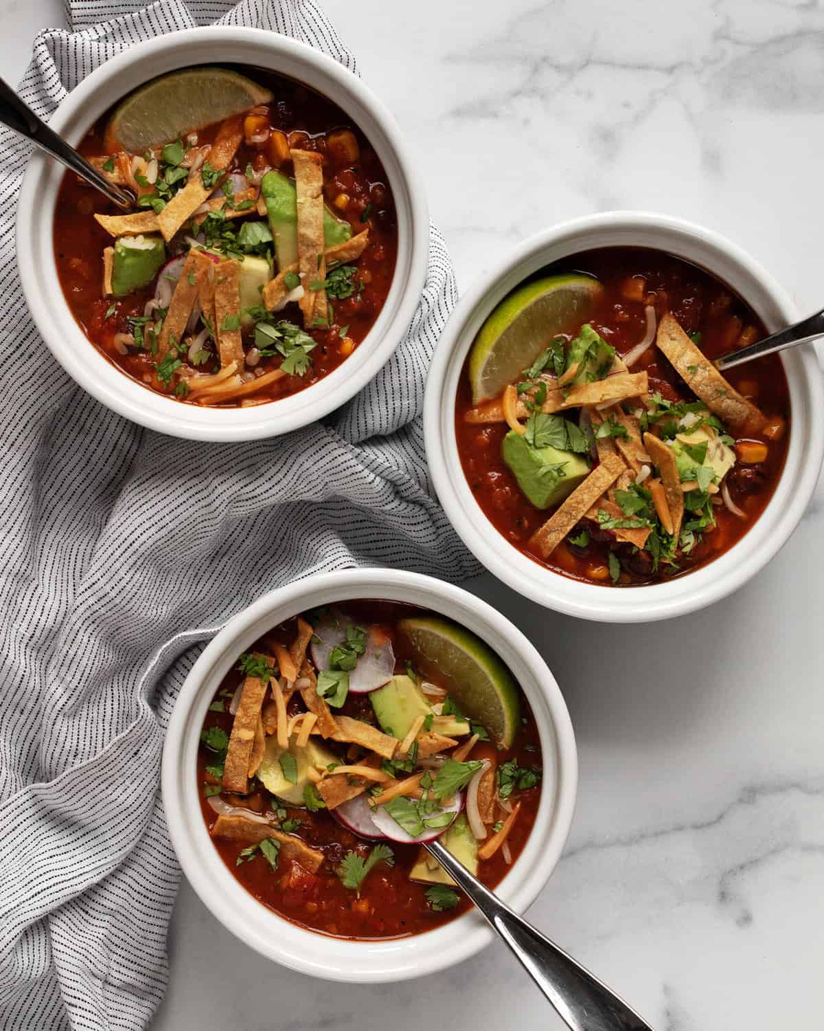 Three bowls of tortilla soup.