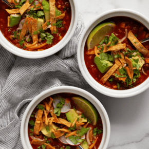 Three bowls of tortilla soup.