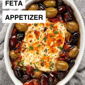 Baked feta in a dish with olives and tomatoes.