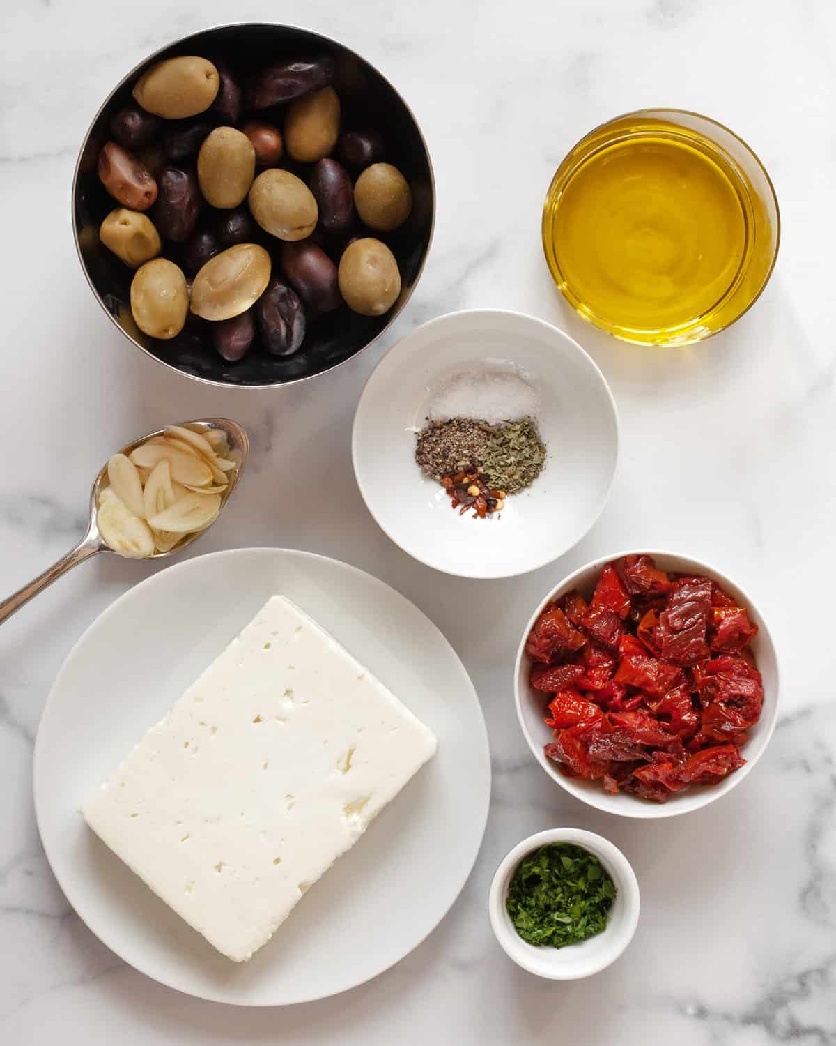 Ingredients including feta, tomatoes, olives, olive oil, garlic and spices.
