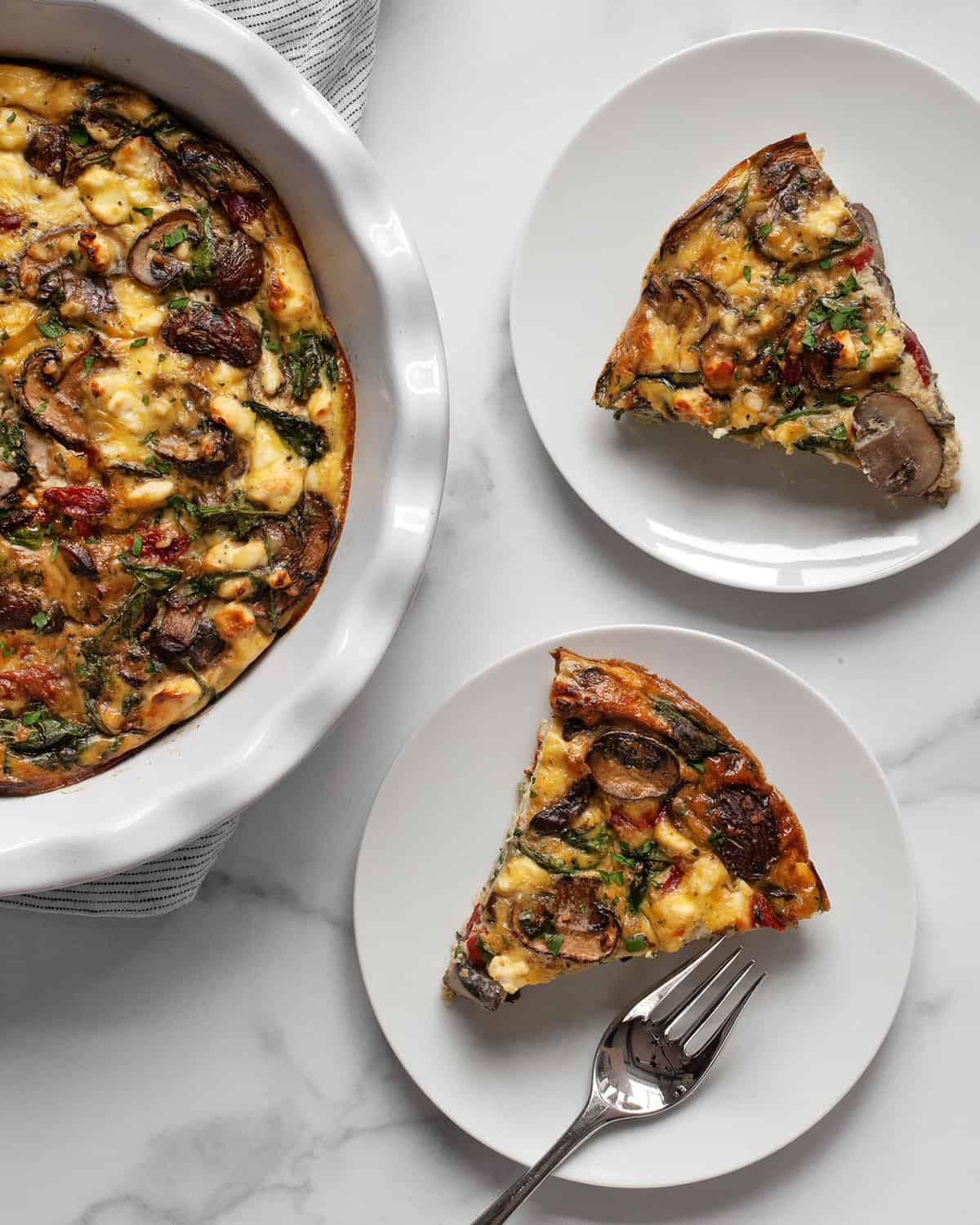 Crustless quiche with mushrooms, peppers, spinach and feta cut into 2 slices.